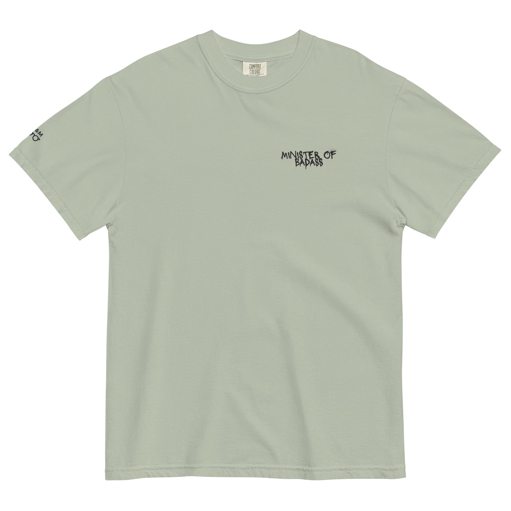 Muted green t-shirt showcasing the 'Minster of Badass' text alongside a bold teddy bear graphic, combining cool tones with an edgy design