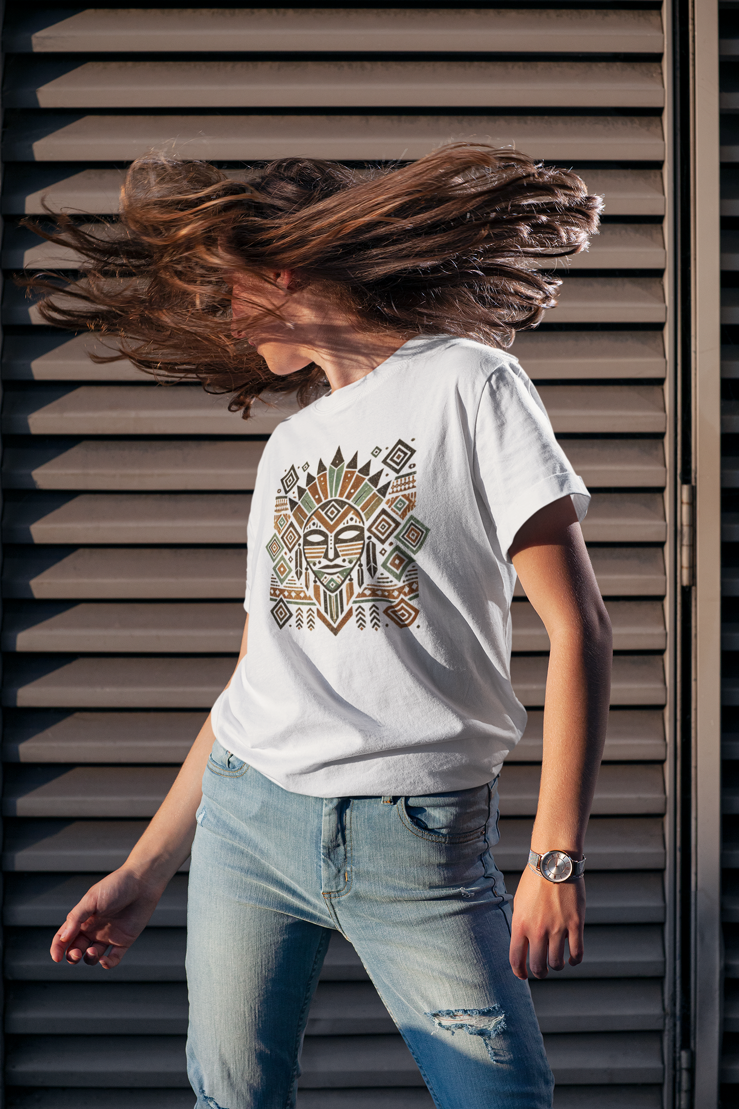 Woman wearing a classic white t-shirt with an Aztec tribal mask print, showcasing intricate geometric patterns in earthy tones.